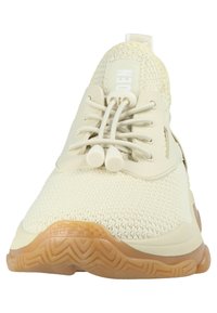 Ljust beige sportskor med överdel i stickat material, säker snörningssystem och en texturerad brun gummisula. Minimalistisk design med logotypdetalj.