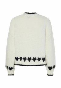 Valge kudum, millel on mustad südame mustrid ääristel, varrukatel ja kaeluses, nähtud tagant.