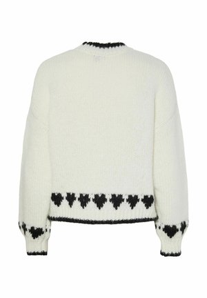 Valge kudum, millel on mustad südame mustrid ääristel, varrukatel ja kaeluses, nähtud tagant.