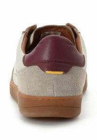 Sneaker mit einem beigen Lederoberteil, einer bordeauxroten Lederferse, grauen Wildlederakzenten und einer braunen Gummisohle. Enthält ein kleines gelbes Detail.