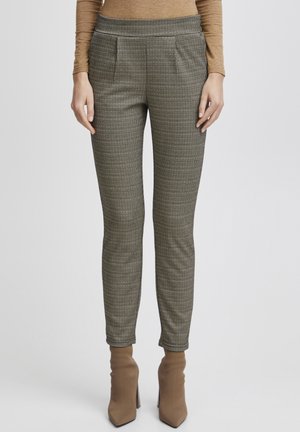 Checked, tailored pants in brown and black, featuring front pleats and a smooth waistband. Paired with fitted brown ankle boots.
