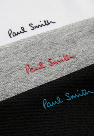 Trzy koszulki T-shirt ułożone jedna na drugiej: biała, szara, czarna. Każda z nich ma logo "Paul Smith" w kontrastowych kolorach haftu: czarnym, czerwonym i turkusowym.
