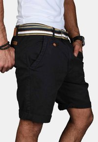 Black cotton shorts with rolled hems, featuring side pockets, a button closure, and a multicolored striped belt. Casual design.