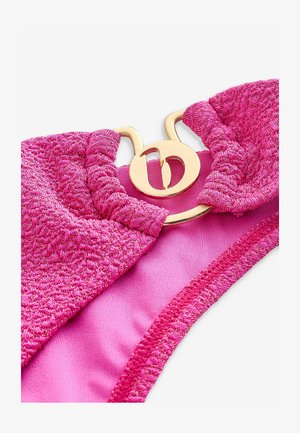 Roza bikini gornji dio s teksturiranim materijalom i metalnom niti, ukrašen zlatnim okruglim detaljem na središtu.