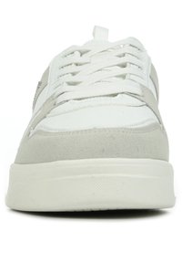 Sneaker grigio chiaro realizzata in pelle e camoscio. Presenta una punta arrotondata, lacci bianchi, suola testurizzata e un design minimalista con accenti.