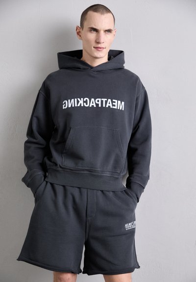Grå hettegenser med hvit tekst "MEATPACKING", stor frontlomme og matchende grå shorts, avslappet passform, myk stofftekstur.
