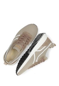 Beige sneakers met een bovenwerk van mesh, leren accenten en een witte swoosh. Dikke zwarte rubberen zool met een geprofileerde grip voor tractie.