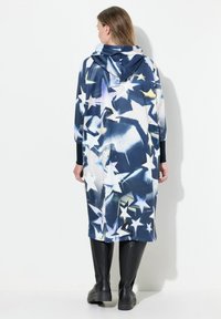 Hoodad, överstor kappa i mörkblått med vita och gula stjärnmönster. Har långa ärmar och knälång design, med en mjuk tygstruktur.