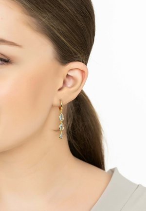 Gold hoop earrings with three teardrop-shaped light blue gems, showcasing a smooth texture and delicate design.