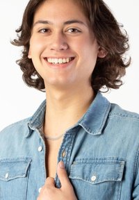 Chemise en denim de couleur bleu clair, boutonnée avec des accessoires en métal argenté, dotée d'une poche poitrine et d'une texture de tissu légèrement effilochée.