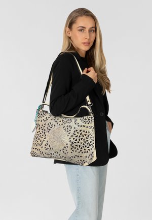 Bolso de mano con un intrincado patrón metálico, color crema y dorado, superficie texturada, asa superior y tirante ajustable.