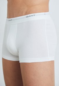 Weiße Baumwoll-Boxershorts mit engem Schnitt, ausgestattet mit einem grauen GANT-Logo am Bund und einer glatten Textur.
