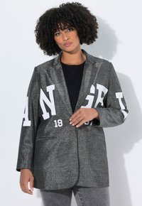 Metallisch grauer Blazer mit weißen "ANGEL"-Buchstaben, langen Ärmeln, Reverskragen und zwei Vordertaschen. Leicht strukturierte Passform.