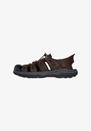 Braune Outdoor-Sandalen mit offenem Mesh-Design, Gummisohle und verstellbarem Schnürsenkel. Verfügbar mit einem schützenden Zehenschutz und orangenen Akzenten auf der Sohle.