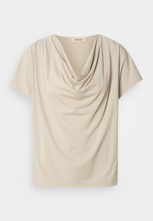 Top bej cu mânecă scurtă, cu guler drapat. Material moale, ușor, cu o textură netedă și o potrivire lejeră. Eticheta este vizibilă la decolteu.