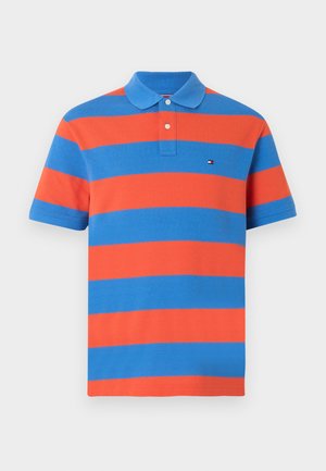 Kortermet polo-skjorte med brede horisontale oransje og blå striper og en to-knappers klaff på en ensfarget bakgrunn.