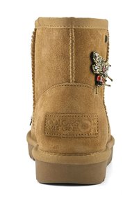 Světle hnědé semišové kotníkové boty s hladkým povrchem, které mají dekorativní akcent v podobě motýla a detail loga na zadní straně.