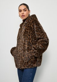 Veste en fausse fourrure marron avec un motif léopard, dotée d'une capuche, de poches avant et d'une silhouette décontractée. Fini texturé et doux.