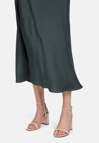 Robe midi bleu canard au design fluide. Assortie à des sandales à talons blocs roses pâles avec des brides aux chevilles et des brides minimalistes.