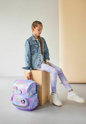 Rucksack mit einem pastellfarbenen Regenbogenmuster, aus weichem Stoff gefertigt, mit einer Vordertasche und einem Tragegriff; kombiniert mit helllila Leggings.