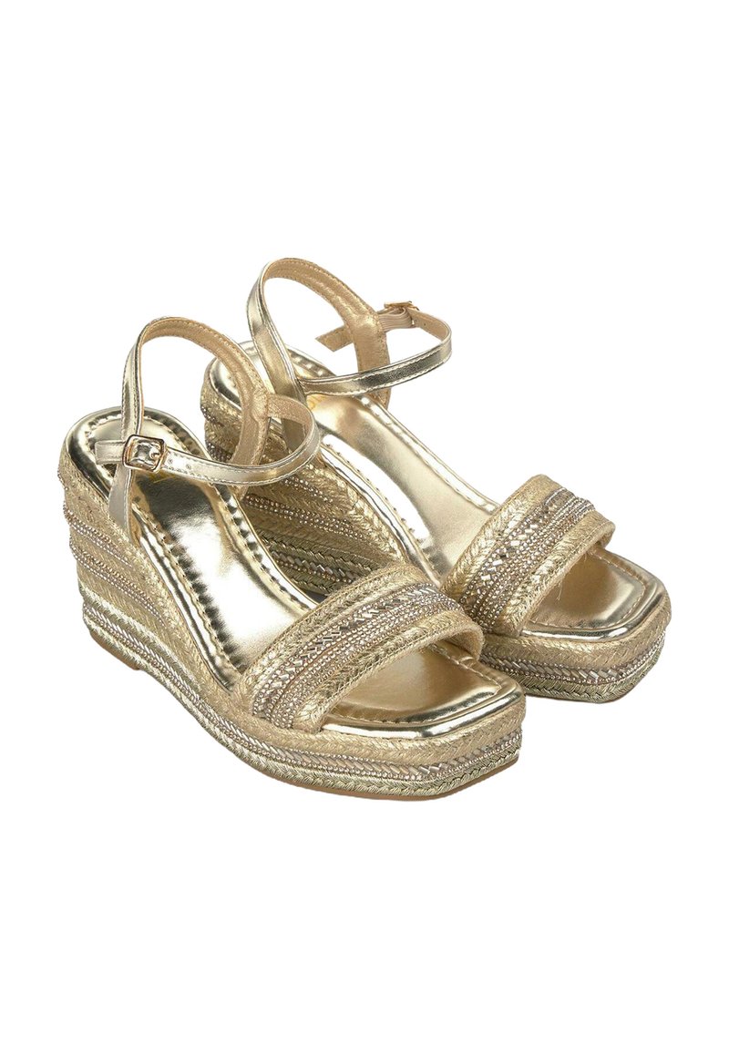 Le sandali wedge in oro presentano cinturini metallici, una piattaforma intrecciata texturizzata e una cinghia attorno alla caviglia. Il design è aperto sulla punta.