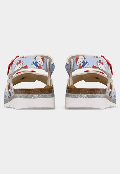 Μπλε σανδάλια παιδικά με εκτύπωση Hello Kitty, κόκκινες φιόγκους, πάτο φελλού, ασημένια επένδυση και λευκή εξωτερική σόλα με ραβδώσεις, εμφανιζόμενα από πίσω.