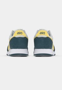 Herresko fra ASICS med grå, gul og mørkegrønn overdel i semsket skinn og mesh, hvit mellomsåle og svart gummisåle.