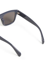 Occhiali da sole con montatura in plastica navy, lenti scure e superficie liscia. Spiccano i bordi curvi e il marchio CE all'interno della tempia.