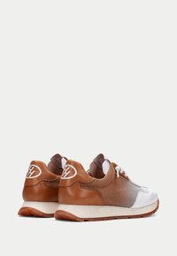 Scarpe da ginnastica marroni e bianche con una struttura in rete, dettagli in pelle liscia e suola in gomma. Presentano un logo sul tallone e un design leggero.