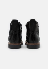 Black ankle boots with a shiny patent finish, crocodile texture, round toe, side zippers, and stitched accents on the heel.