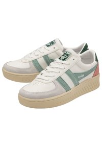 Baskets blanches avec des accents verts et rose clair, en cuir texturé et en suède, dotées de trois bandes, d'une pointe ronde et d'une épaisse semelle beige.