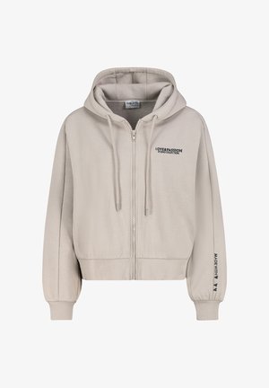 Hellbeige Kapuzenjacke mit Reißverschluss und Kordeln, vorne Text „LOVE & PASSION STUDIO COLLECTION“ und Ärmelschrift „MADE WITH“ plus Herzen.