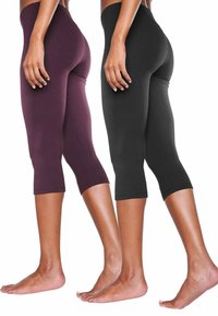 Twee paar capri-leggings: één in donkere bordeauxrood en één in zwart. Gemaakt van rekbaar materiaal met een aansluitend ontwerp en een cropped leg.