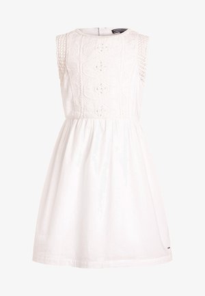 Robe blanche sans manches avec un corsage en tricot texturé, un col rond et une jupe froncée, fabriquée à partir d'un tissu léger.