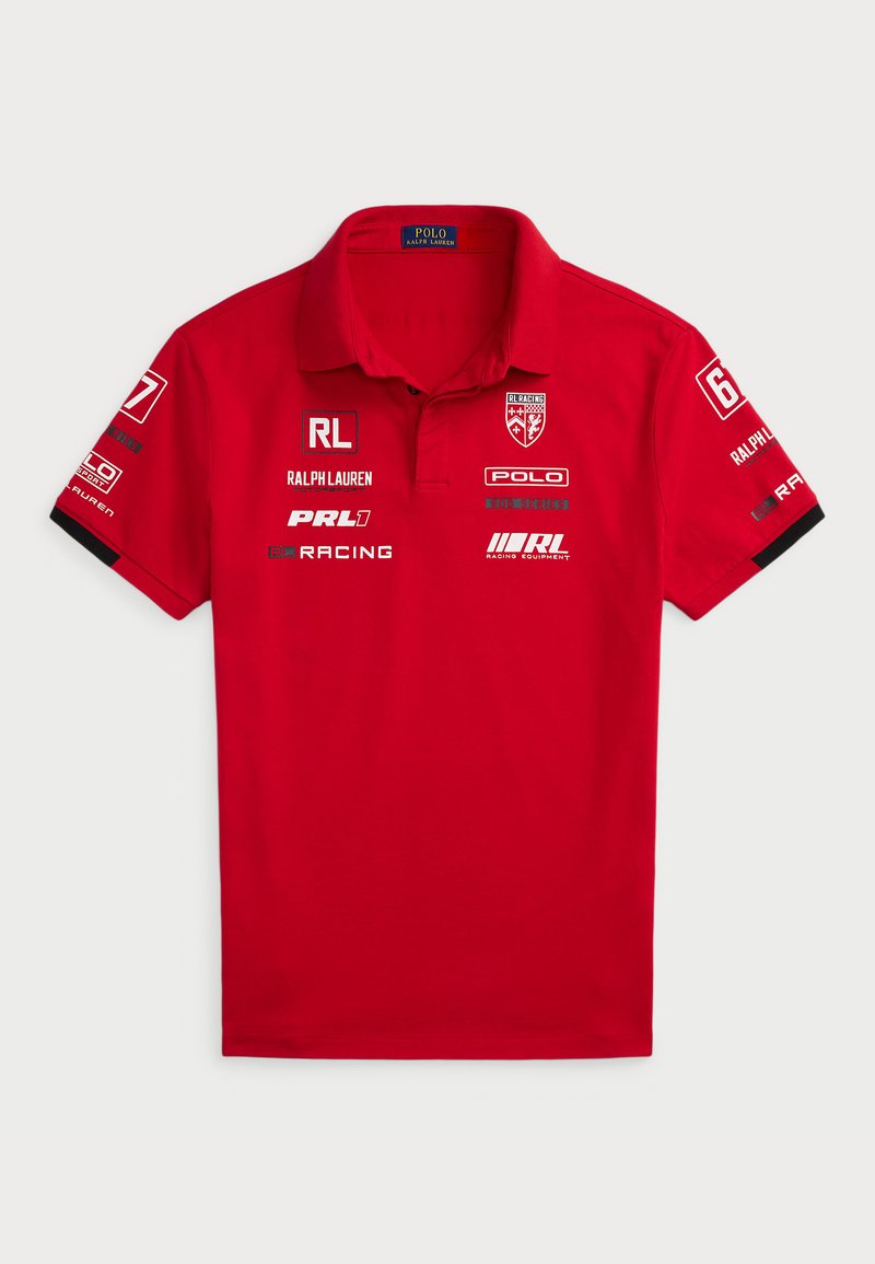 Rød bomullspolo med krage, korte ermer og flere trykte logoer, inkludert "Ralph Lauren" og racingmotiver på ermed