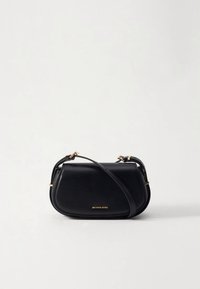 Melna ādas plecu soma ar izliekta silueta formu, zelta krāsas metāla detaļām un plecu siksnu; priekšpusē izceļas pamanāms logotips.