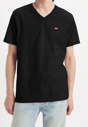 Zwarte katoenen v-hals t-shirt met korte mouwen, met een klein rood Levi's logo op de linkerborst en een relaxte pasvorm.