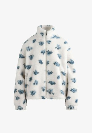 Jachetă din fleece alb cu model floral albastru, guler înalt, fermoar frontal complet și manșete elastice. Textură moale și croială lejeră.
