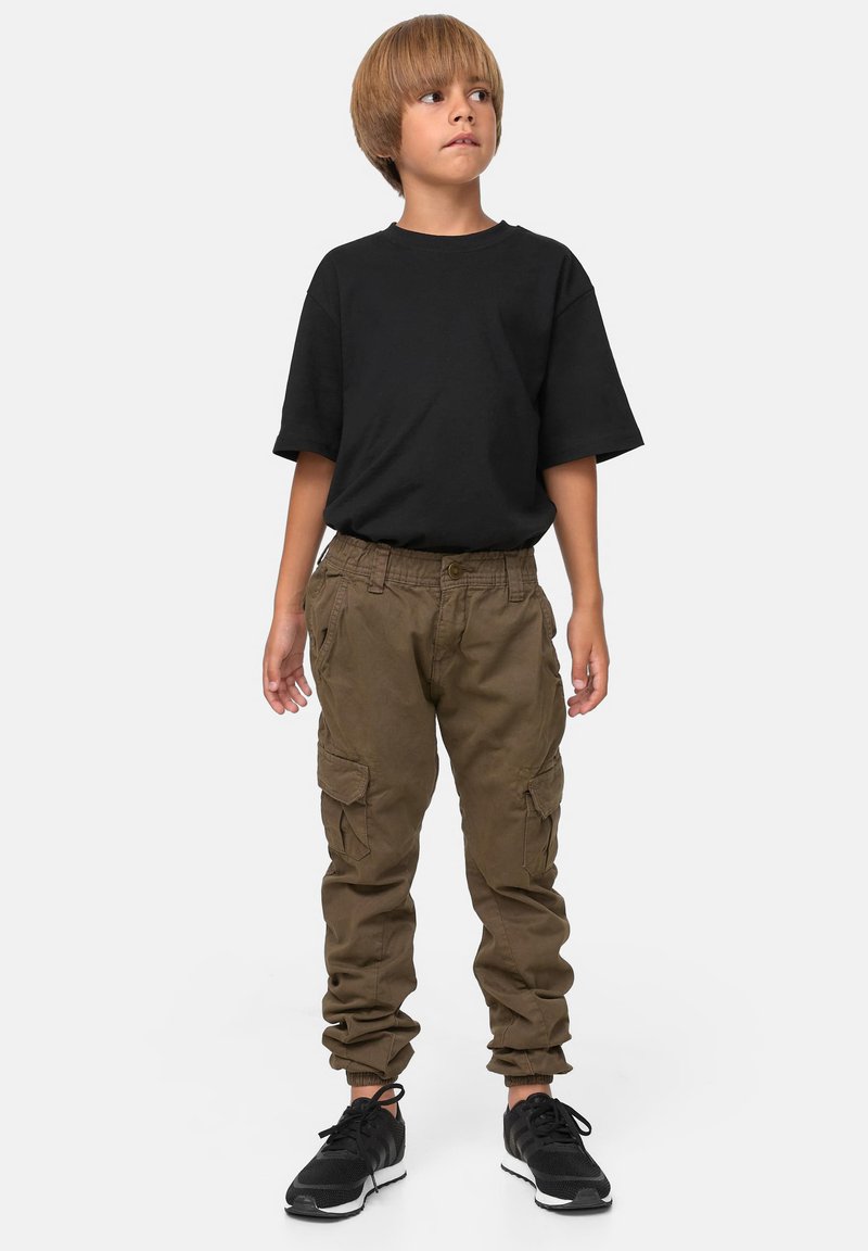 Svart t-skjorte med korte ermer, brune cargobukser med elastiske mansjetter og sidelommer, og svarte joggesko. Enkel, funksjonell design.