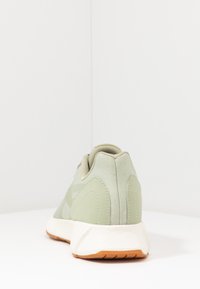 Světlé zelené tenisky s hladkým, strukturovaným svrškem a podpůrnou patou. Disponují bílou mezipodešví a gumovou podrážkou pro lepší trakci.