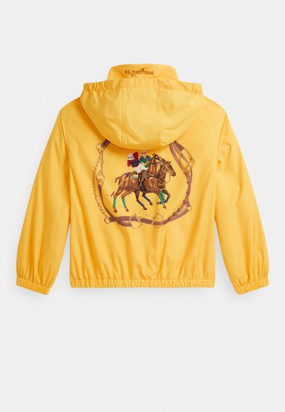 Żółta kurtka z kapturem z elastycznymi mankietami, na plecach z grafiką przedstawiającą dwóch graczy polo na koniach w kole z skórzanym uzbrojeniem.