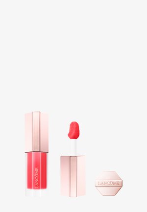 Gloss à lèvres Lancôme fermé et ouvert avec bouchon rose, applicateur rouge visible et bouchon hexagonal embossé du logo de la marque, sur fond blanc.