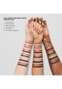 Dobbeltsidig kremøyenskyggepinne med swatches på tre armer. Den inneholder seks par fargekodede nyanser i ulike toner fra lys til mørk.