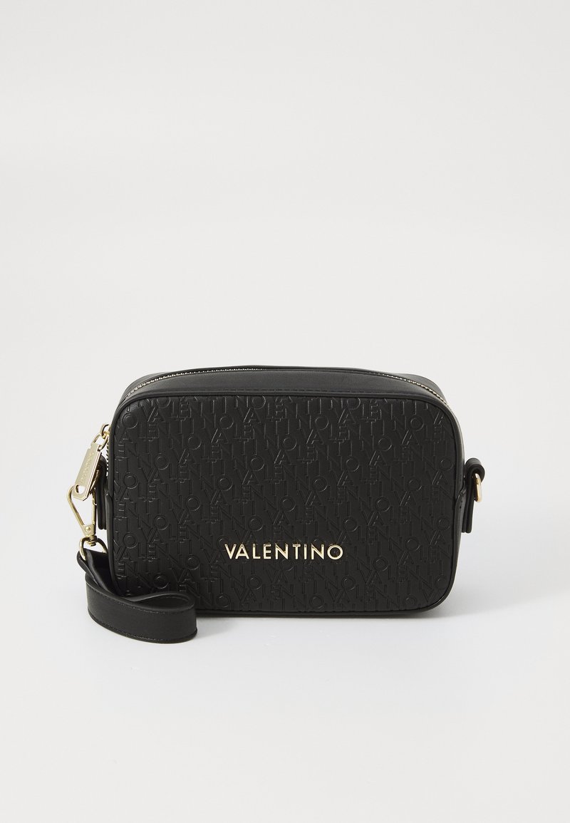 Sac bandoulière en cuir noir avec un motif de logo embossé, des finitions dorées et une bandoulière amovible. Forme rectangulaire avec fermeture éclair.