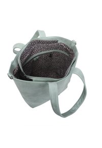 Miętowa torba typu tote o gładkiej fakturze, z ciemnym wnętrzem z różowym wzorem w kropki, dwiema wewnętrznymi kieszeniami i wytrzymałymi uchwytami.