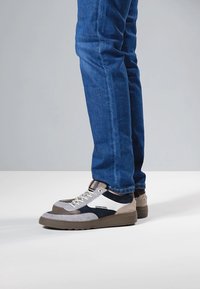 Grau-blaue Sneaker aus Veloursleder und Mesh, mit einem geschichteten Design, strukturierten Sohlen und kontrastierenden weißen Akzenten.