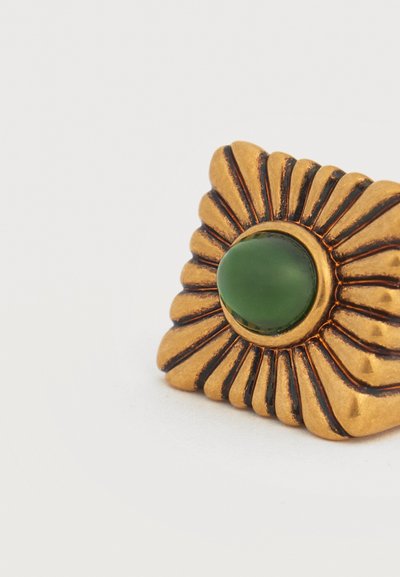 Αντικέ καρφίτσα από μεταλλικό υλικό σε χρυσοκίτρινο τόνο με σχεδιασμό ακτινωτών πέταλων και κεντρική λεία πράσινη οβάλ πέτρα, σε απλό λευκό φόντο.