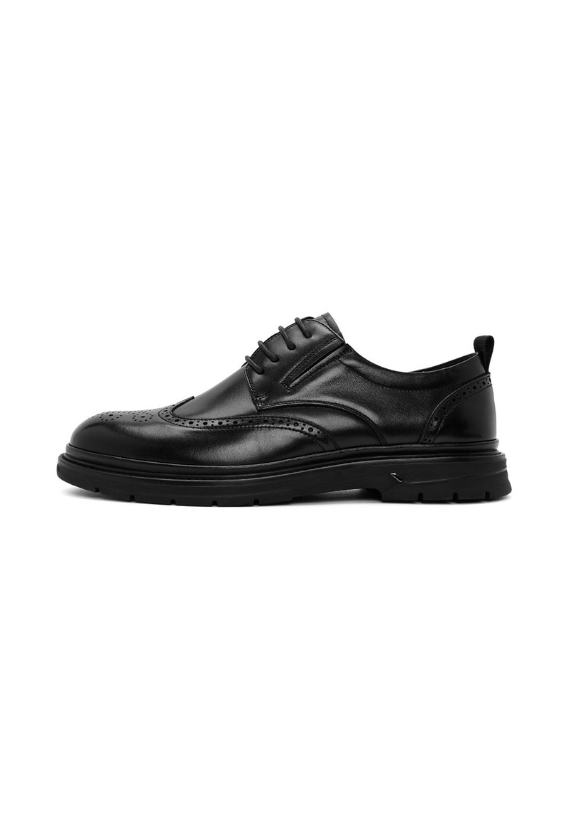 Zwarte leren schoen met brogue-details, lage rubberen zool, vetersluiting en een gladde afwerking. Inclusief decoratieve stikaccenten.