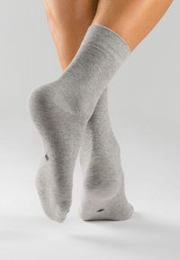 Graue Baumwollsocken mit einem gerippten Bündchen, die eine glatte Textur aufweisen, knöchellang sind und dezente dunkle Akzente an der Ferse haben.