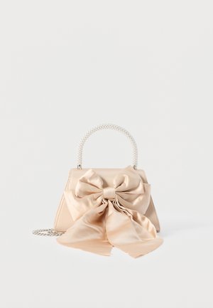Beige satin handbag with large matching decorative bow, pearl-beaded handle, and silver chain strap on white background.